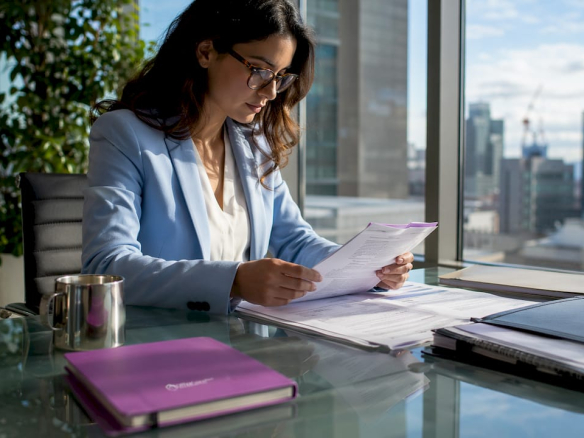 Professional reviewing documents in traditional office