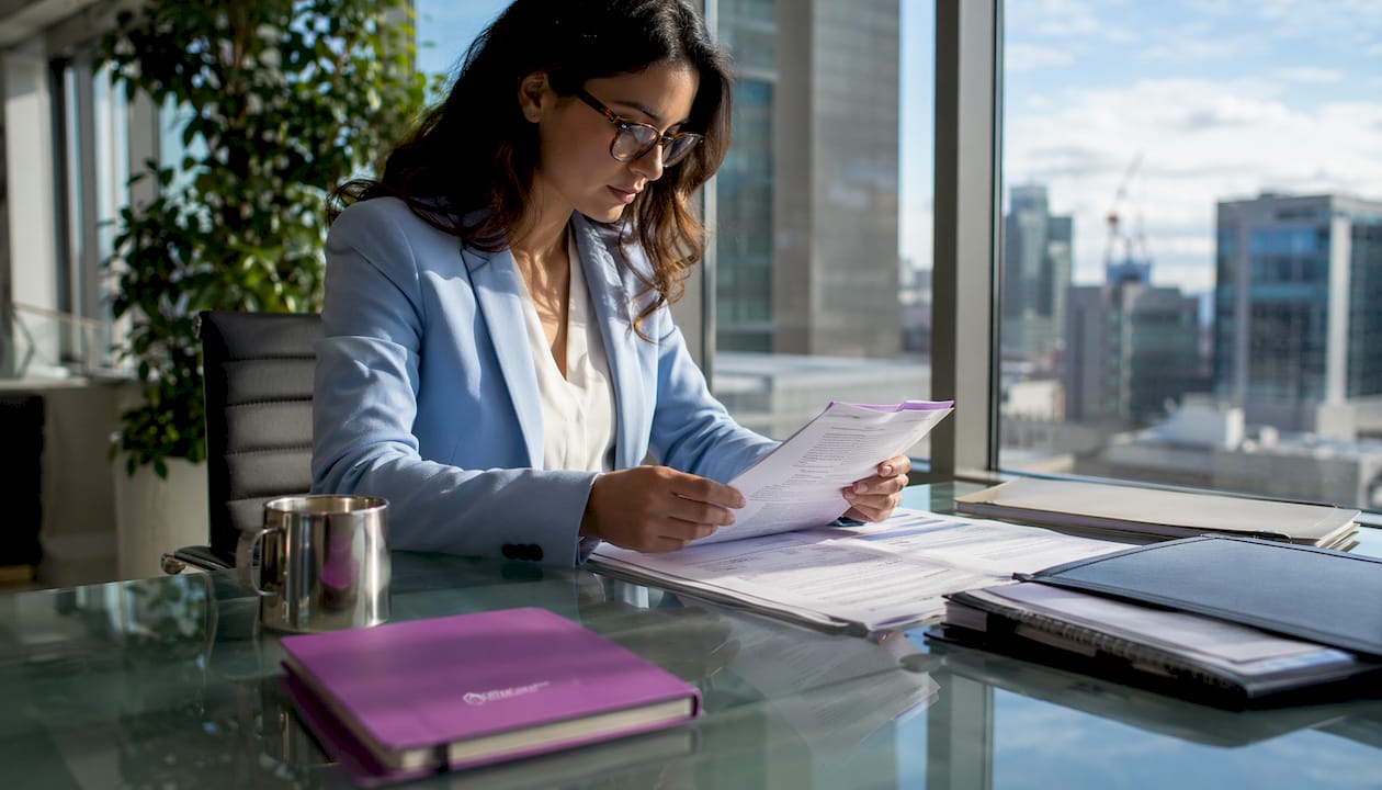 Professional reviewing documents in traditional office