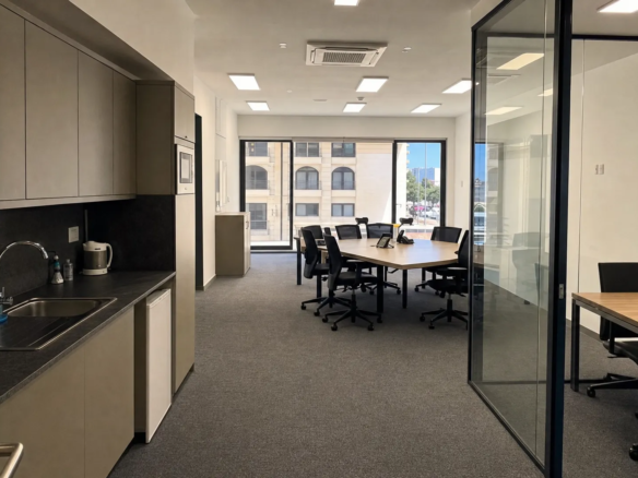 A small Malta office suite shows a rectangular work area, glass partitioned room and compact kitchenette in one usable layout.